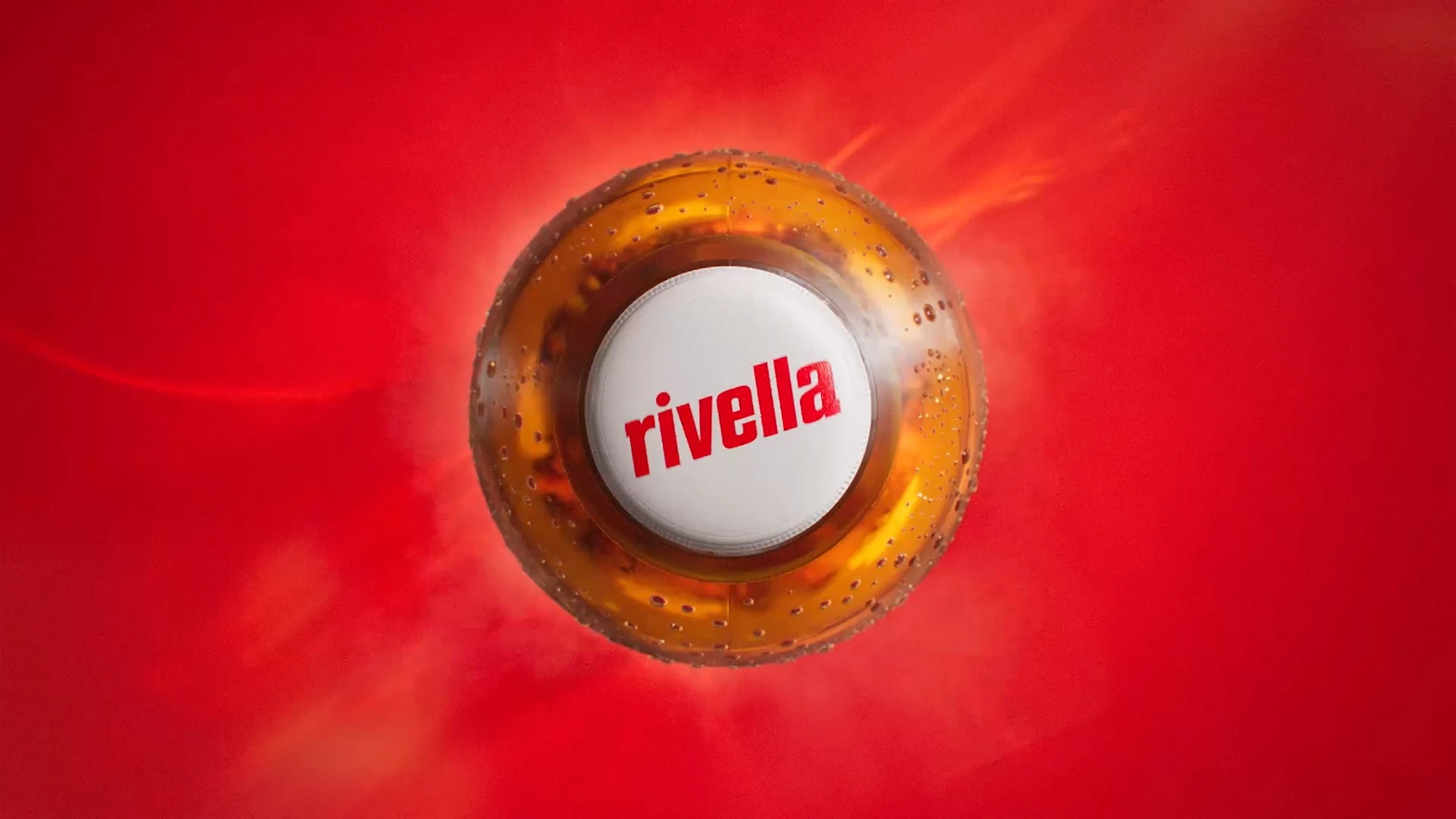 Rivella bottle cap surrounded by golden liquid against red